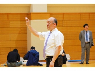 丸めた紙を用いて飛び方を説明する大竹教授