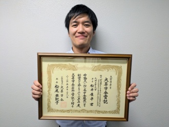 受賞した松井助教と表彰状