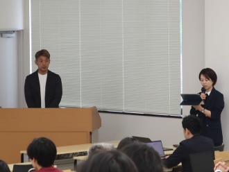 開所記念講演会の様子1 (左: デンソー九州 高咲 龍樹氏)