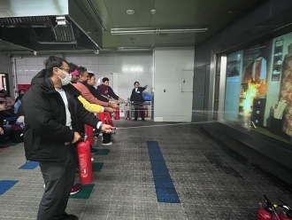 Participants practicing fire-extinguisher operation during a hands-on training session at the Fukuoka City Disaster Prevention Center.