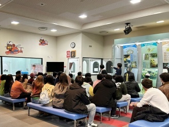 International students listening attentively to the instructions before a smoke-evacuation drill.